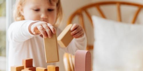 Deklica, ki se igra z lesenimi igračami