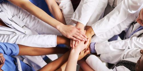 Zdravstveni delavci z rokami ena na drugi 